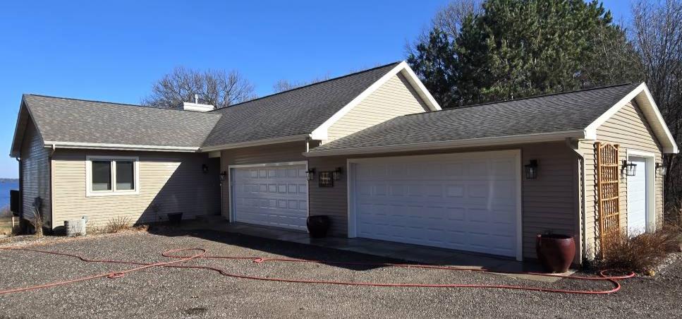Siding we soft-washed on a house and garage In Necedah, Wisconsin